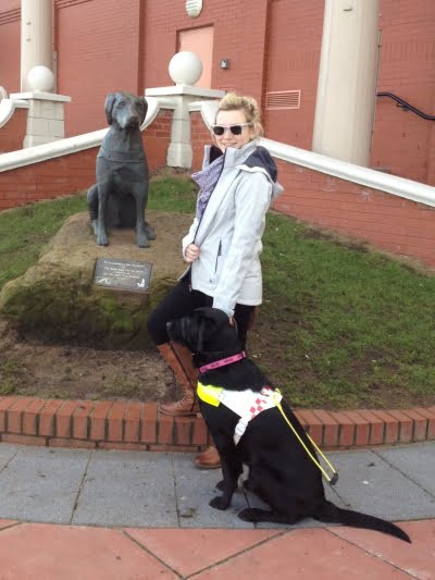 Molly and guidedog Unis standing next to the statue of first ever guidedog in the UK.