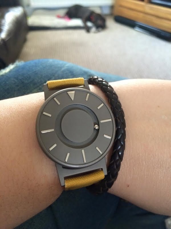 Close up picture of a Bradley tactile watch which has a mustard coloured strap.