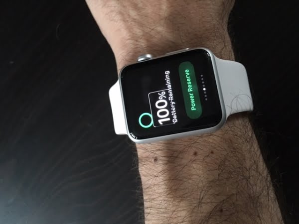 A white strapped applewatch the face displaying the watch to be 100% charged.