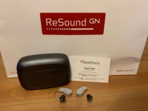 Resound hearing aids, a Resound charger box and a Correct hearing Limited card.